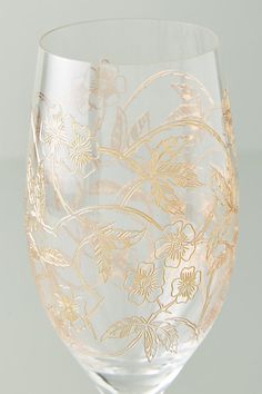 a wine glass with gold floral designs on it