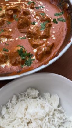 there is a bowl of rice and meat in the dish on the table next to it