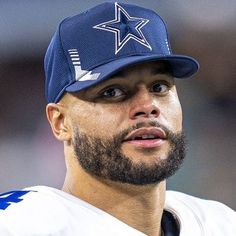 a close up of a football player wearing a hat and looking off to the side