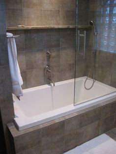 a bathroom with a bathtub, shower and towel rack