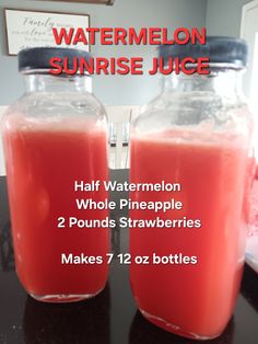 two glass jars filled with watermelon juice on top of a table