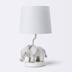 an elephant lamp with a white shade on it's head is shown in front of a white background