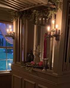 candles are lit in front of a window with pineapples and other holiday decorations