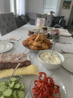 the table is set with many different types of food on it, including cucumbers and cheese