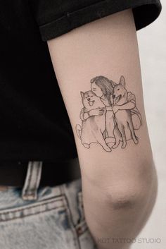 a person with a tattoo on their arm holding a cat and hugging it's back