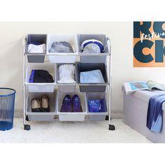 an organized closet with clothes and shoes on it, next to a blue trash can