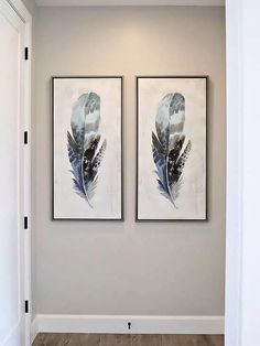 two paintings hanging on the wall next to each other in a room with wood flooring