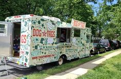 the food truck is parked on the side of the road in front of some trees