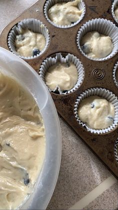 cupcake batter in a muffin tin with blueberries