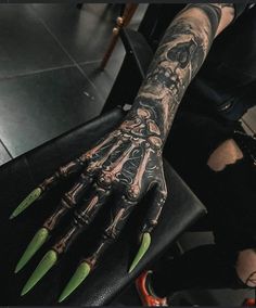 a person with green nails on their arm and hand is holding up a black bag