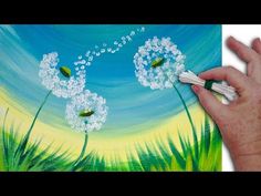 someone is painting dandelions on a canvas with acrylic paint and glue