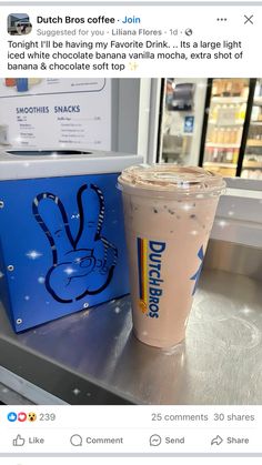 a dunkin donuts drink sitting on top of a counter next to a sign