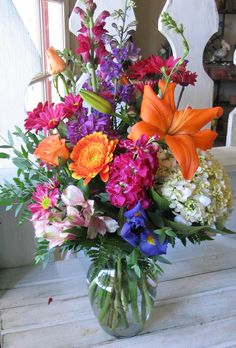 a vase filled with lots of colorful flowers