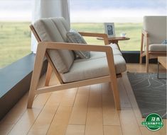 a living room with two chairs and a table in front of a large open window