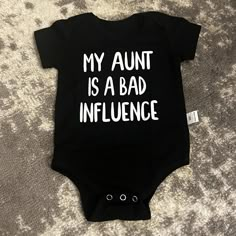 This Listing Is For A Baby Short Sleeve Unisex Onesie. It Is Black On The Front In White Letters It Says, "My Aunt Is A Bad Influence." It Is Unbranded, Size 9 Months. This Onesie Is New Without Tags. It Comes From A Non-Smoking Home. I Will Accept Reasonable Offers On Some Items. I Don’t Discount New Items.. And Will Not Take 50% Off Offers. Auntie Baby Onesies, Cute Onesies For Babies, Funny Aunt Onesie, Alternative Baby Clothes, Goth Baby Clothes, Aunt Baby Clothes, Baby Onesie Ideas, Aunt Onesie, Funny Baby Shirts