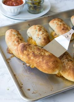 someone is cutting up some bread on a tray