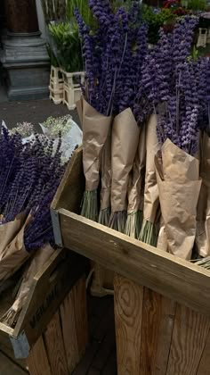 lavender flowers in brown paper bags sitting on wooden crates