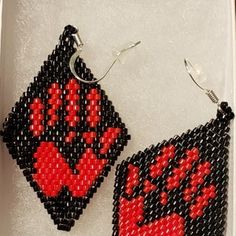 the beaded earrings are decorated with red and black designs