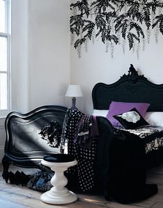 a bedroom with white walls and black furniture