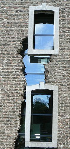 the reflection of two windows in an old brick building