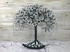 a wire tree with white flowers on it