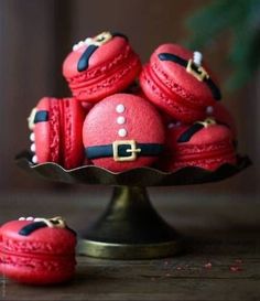 some red macaroons are sitting on a plate