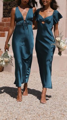 two women in blue dresses are walking together