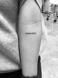 a person with a tattoo on their arm that says,'legendary'in black ink