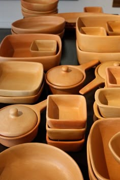 a table topped with lots of wooden bowls and plates covered in different shapes and sizes