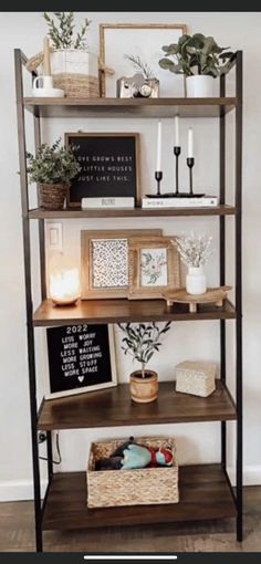 a shelf with some plants and pictures on it