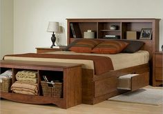 a bed sitting on top of a wooden floor next to a night stand with two lamps