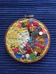 a close up of a embroidery on a piece of cloth with beads and flowers in it