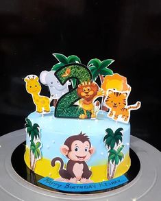 a birthday cake decorated with animals and trees