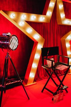 a red stage with lights and a camera on a tripod in front of a star