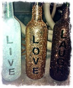 three glitter bottles with love written on them