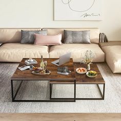 a living room with a couch, coffee table and pictures on the wall above it