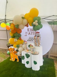 a table with balloons and decorations on it in the shape of a lion under a tent