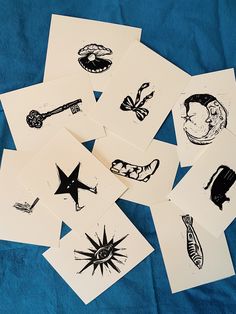 several different types of ink drawings on white paper with blue cloth behind them, all in black and white