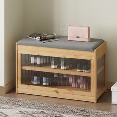 a small wooden cabinet with glass doors and shelves on the top, next to a rug