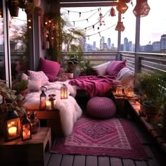 a balcony with lots of plants and candles on the floor, lights strung from the ceiling