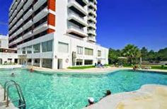 an outdoor swimming pool next to a tall building