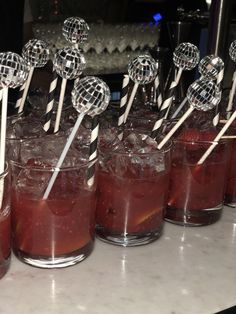 there are many cocktails on the table with lollipop sticks sticking out of them