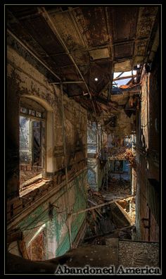 an old run down building with lots of windows and debris on the floor, in disrepair