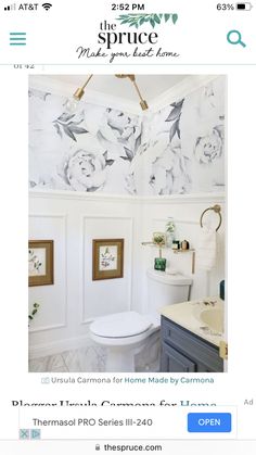 the bathroom is decorated in white and gray with flowers on the wall above the toilet