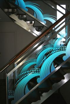 an image of a stair case with blue circles on the glass and metal handrails