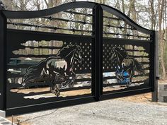 a large metal gate with horses painted on the side and an american flag behind it