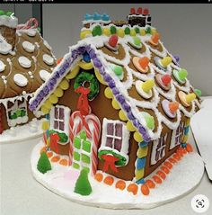 two gingerbread houses are decorated with candy and candies on the top one is made out of icing