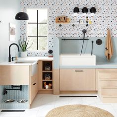 a kitchen with blue and white wallpaper, wooden cabinets and sink in the center