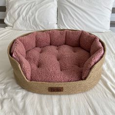 a pink dog bed on top of a white bed