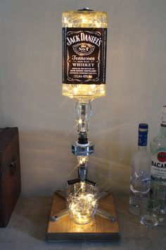 a light up bottle sitting on top of a wooden table next to a liquor bottle